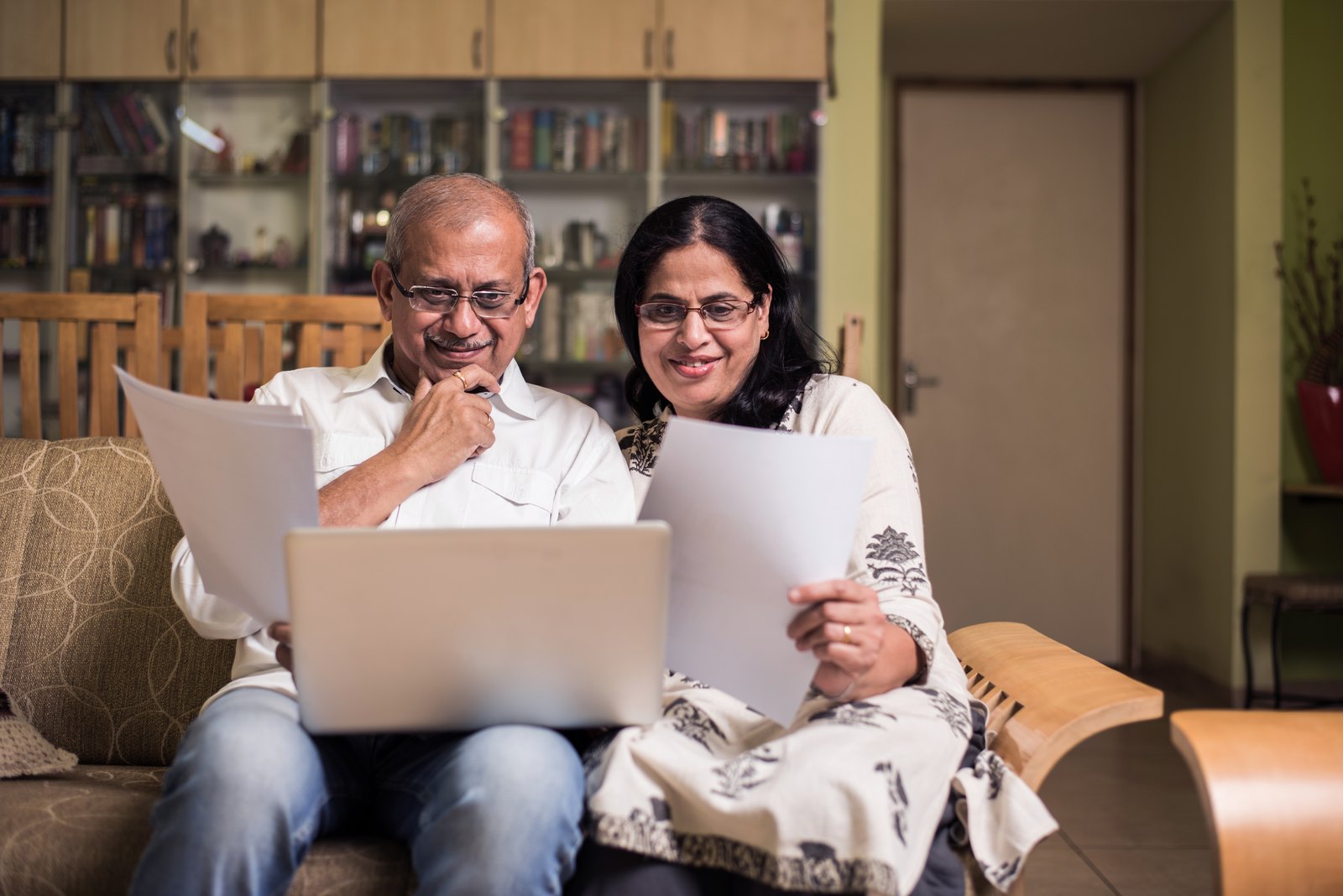 A senior Indian couple reading documents together at home